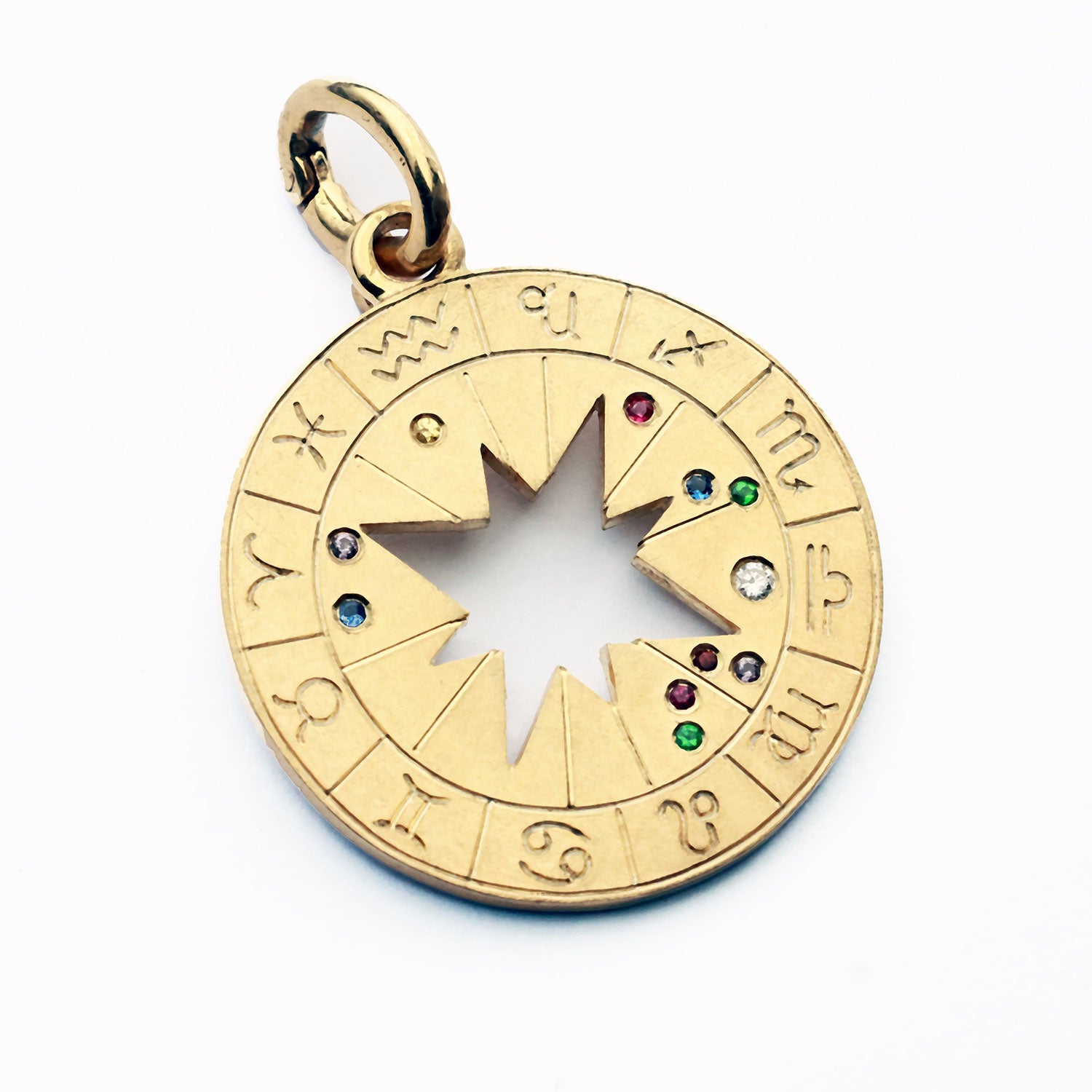 Der Astro Diamond Mini Gold ist ein runder Anhänger (2,9 cm Durchmesser), der das persönliche Geburtshoroskop seines Trägers abbildet. In der Mitte strahlt ein ausgestanzter Stern, umgeben von den zwölf Tierkreiszeichen als feines Relief. Die Positionen der Himmelskörper zum Zeitpunkt der Geburt – Sonne, Mond und Planeten – werden durch echte Edelsteine markiert und machen jedes Stück zu einem einzigartigen Talisman.